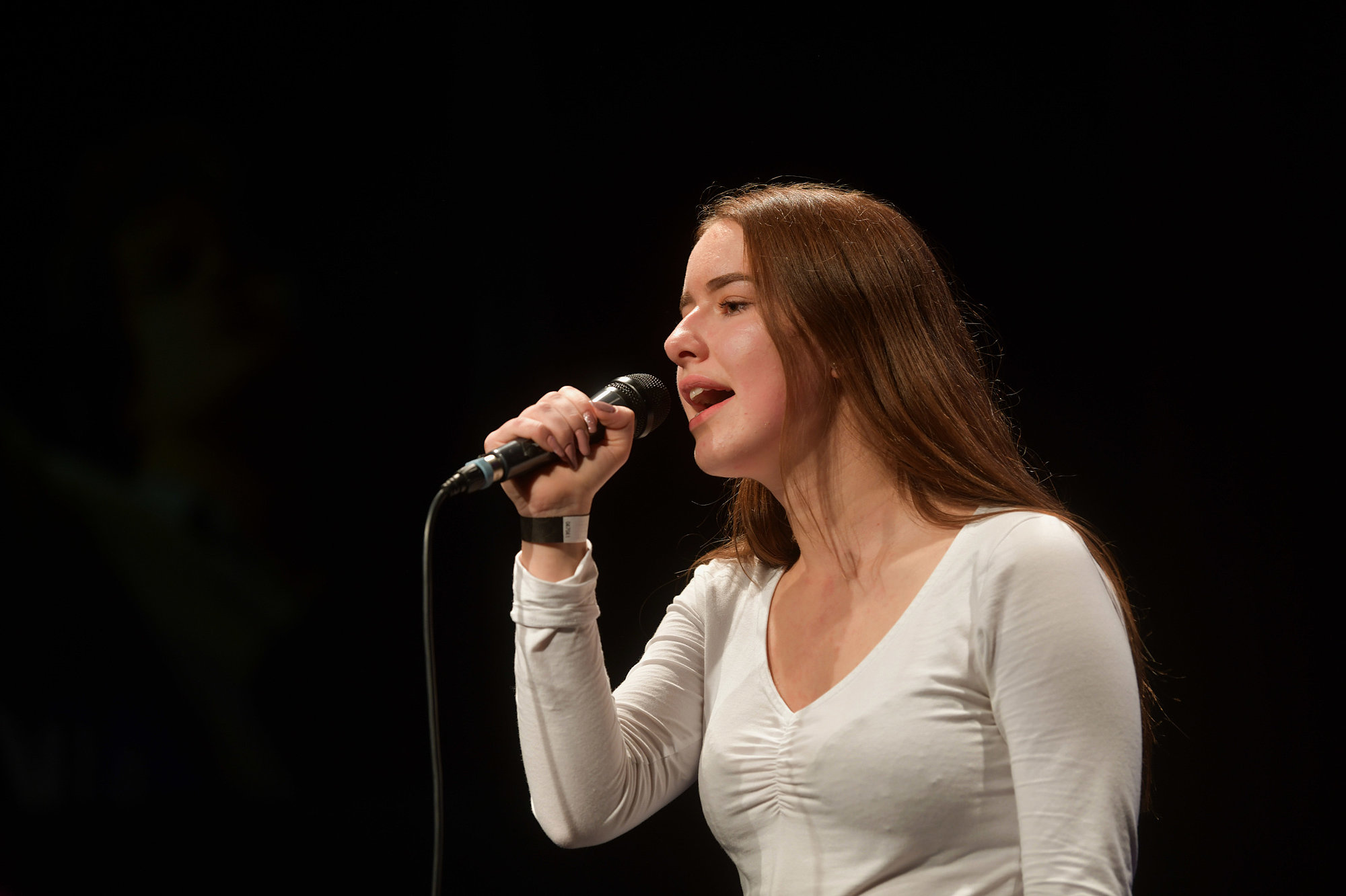 eine Schülerin der Musikschule singt in ein Mikrofon