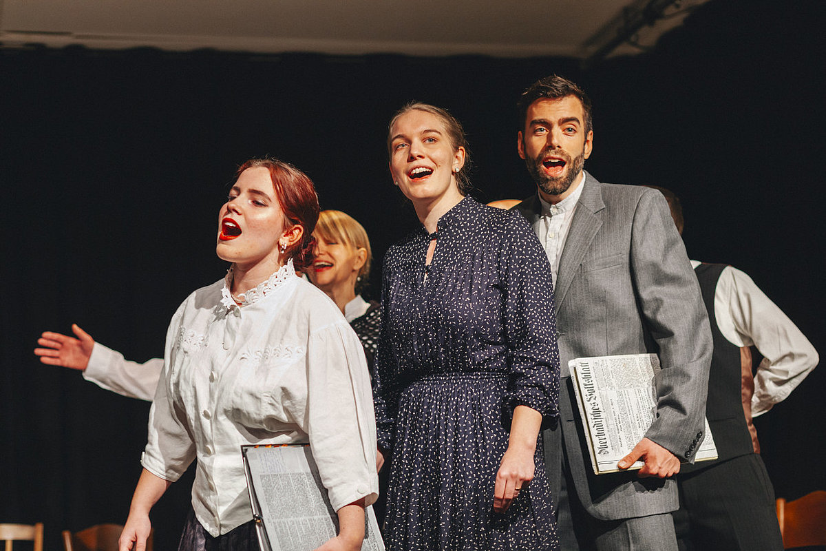 zwei Frauen und ein Mann singen im Chor